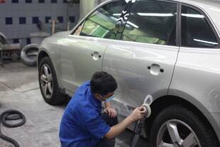 工人专注维修银色汽车