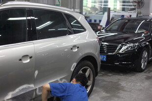 工人维修车间内的汽车