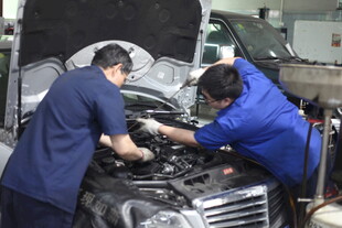 汽修工人专注检修汽车