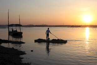 夕阳下的水上独舟身影