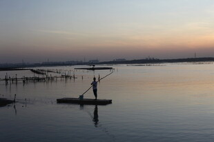 夕阳下湖面的独舟身影