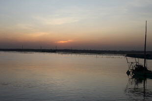 夕阳下的宁静湖面与孤舟