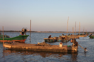 夕阳下的水上渔船景象
