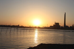 夕阳下的水域与远处烟囱