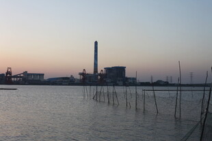 黄昏下的水边工厂景象