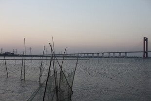 黄昏下的江畔与远处桥梁