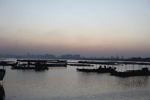 黄昏下宁静的江面船只景