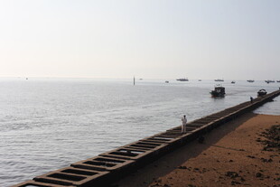 海边延伸的铁轨与船只