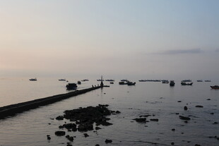 海边黄昏下的礁石与船只