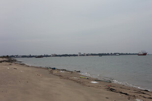 宁静海边沙滩与远处船只