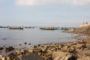 海边礁石旁停泊的多彩船只