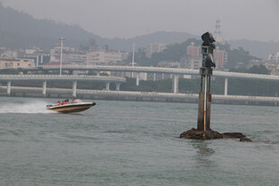厦门海边上小船与岸边雕像景观