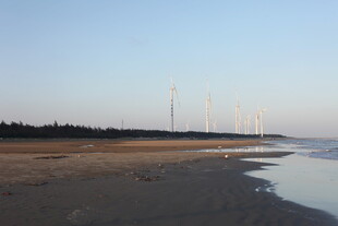 海边沙滩与远处风力发电机