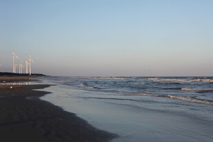 海边暮色中的海浪与风车