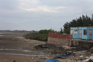 海边破旧小屋与荒芜滩涂