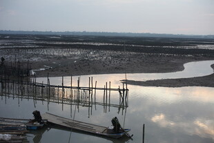 河畔暮色中的简易捕鱼场景
