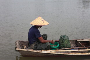 水乡渔夫驾舟撒网