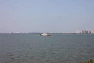 海上孤舟与远处城市景观