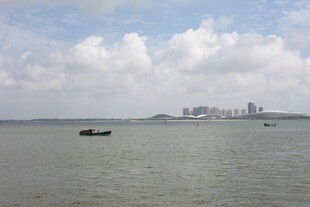 海上孤舟与远处城市景观