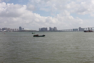 海上孤舟与远处城市景观