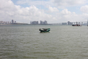 海上孤舟与远处城市景观