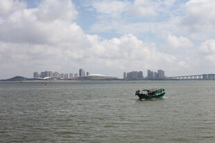 海上孤舟与远方城市景观