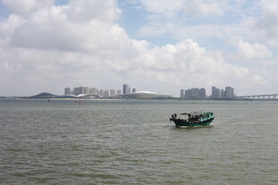 海上孤舟与远处城市景观