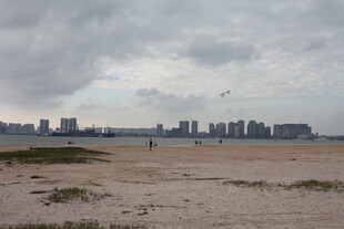 阴天的城市边空旷沙滩景色