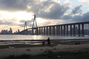 夕阳下的大桥与岸边行人