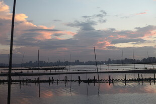 黄昏湖畔静谧水面与远帆
