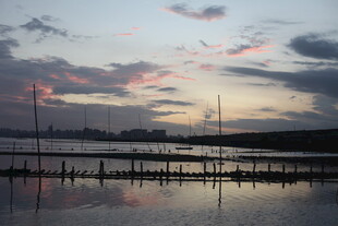 黄昏海港静谧水面映霞光