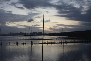 黄昏下宁静的水面与桅杆