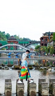 女子撑伞漫步水上石墩