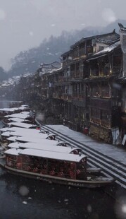 雪中古镇河畔船只景象