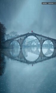雾中拱桥映于平静水面