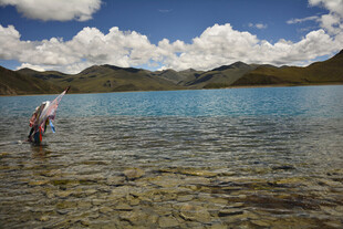 人在清澈湖水中漫步