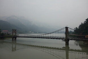 雾中河畔吊桥风景