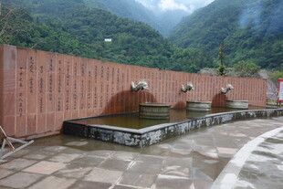 户外红墙下的石质水景装置