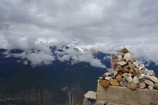 山间石堆与远处云雾雪山