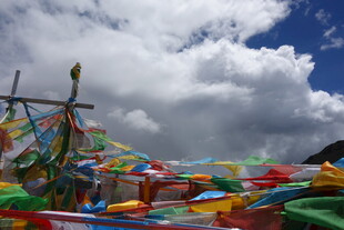 五彩经幡飘扬于蓝天白云下