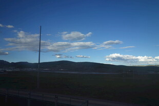 蓝天旷野间的电线杆