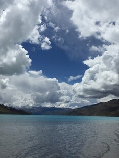 蓝天白云下的静谧湖水