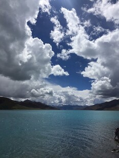 蓝天白云下的静谧湖水