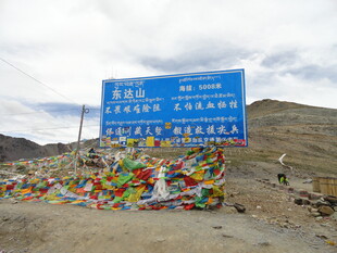 西藏路牌与五彩经幡景观