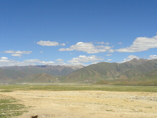 广袤荒原与远处山峦蓝天