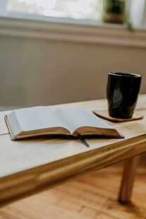 窗边桌上翻开的书与咖啡杯