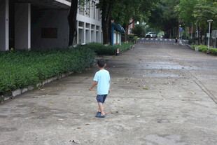 小孩独自走在户外道路上