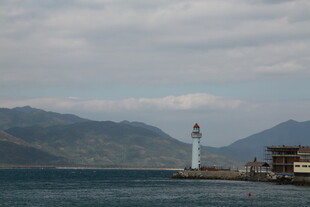 海边灯塔与远处山峦美景