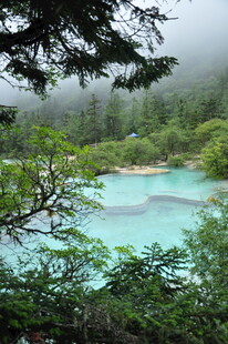 云雾中的幽美翠绿湖泊