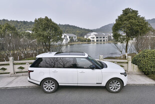 白色家用车停靠湖边美景处